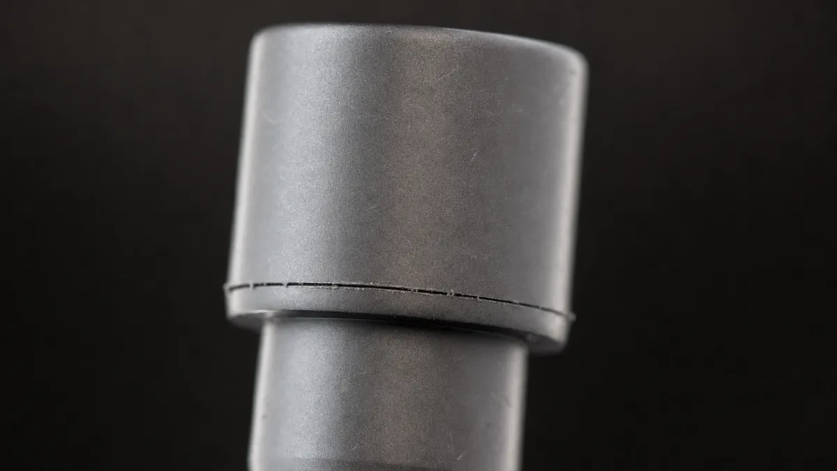 The same detail with typical replica flaws: crooked stitching, glue residue, rough edges